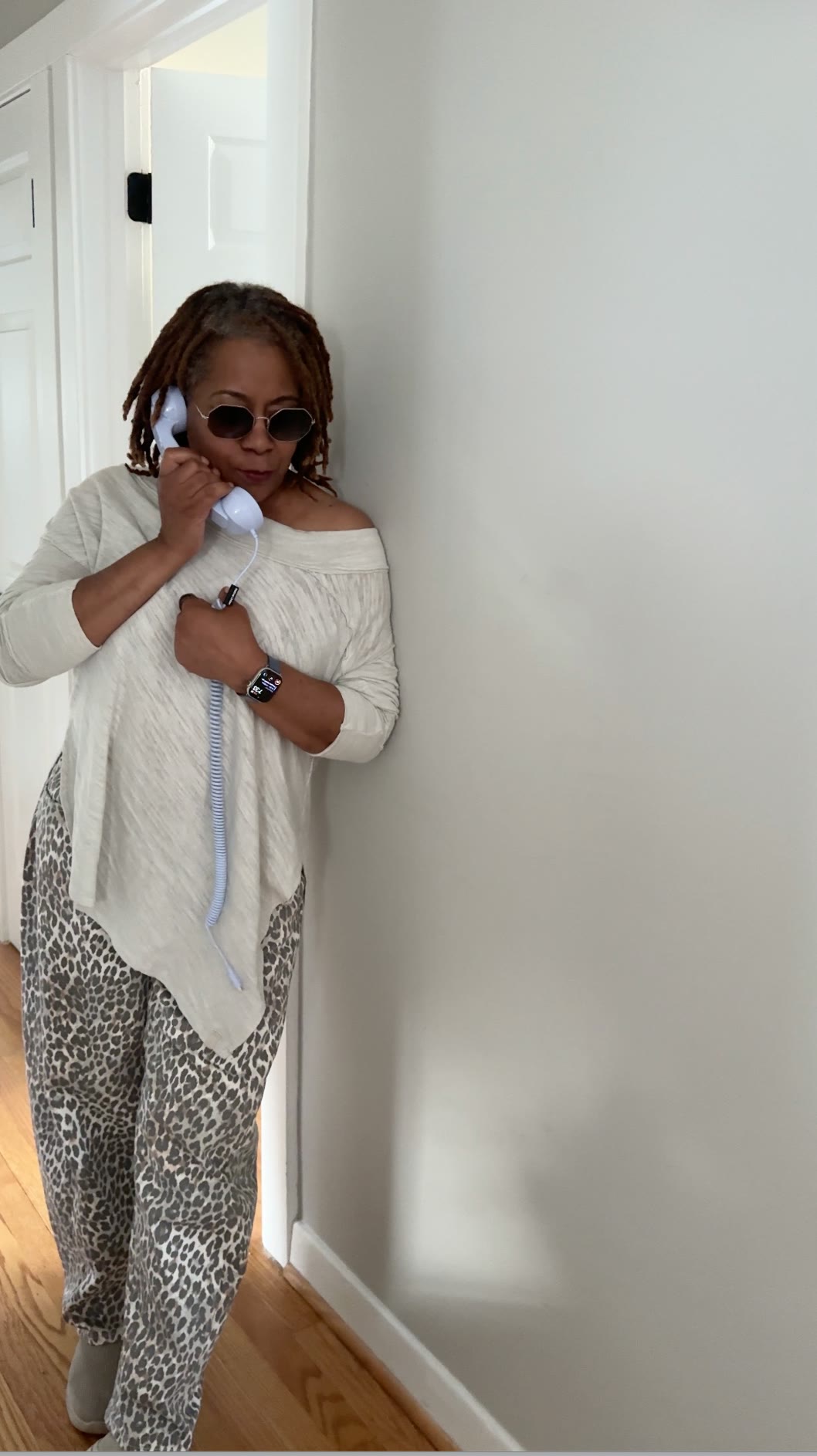 Renita Martin speaking on a corded telephone handset in a hallway.